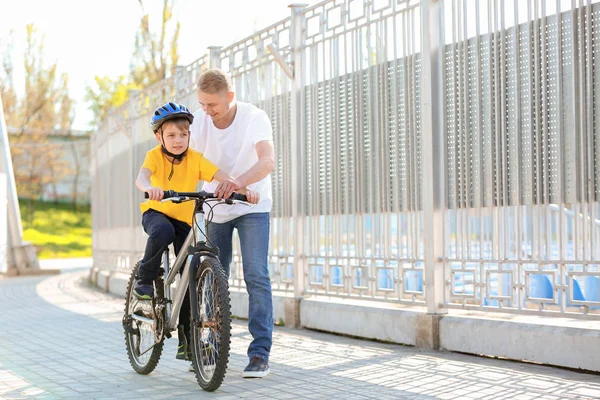 父は息子に屋外で自転車に乗るように教える — ストック写真