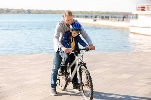 Pai ensinando seu filho a andar de bicicleta ao ar livre — Fotografia de Stock