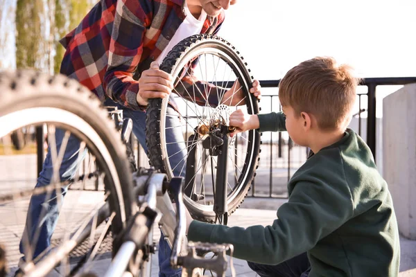 Ο πατέρας και ο γιος του επισκευάζουν ποδήλατα σε εξωτερικούς χώρους — Φωτογραφία Αρχείου