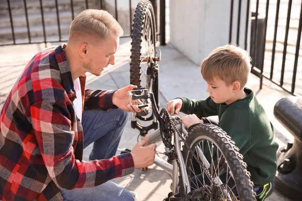 父と息子が屋外で自転車を修理 — ストック写真