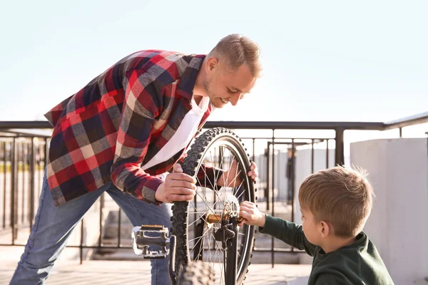 父と息子が屋外で自転車を修理 — ストック写真