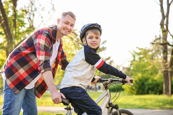 父亲教儿子在户外骑自行车 — 图库照片