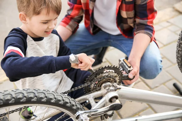 父と息子が屋外で自転車を修理 — ストック写真