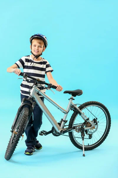 Little boy with bicycle on color background — Stock Photo, Image