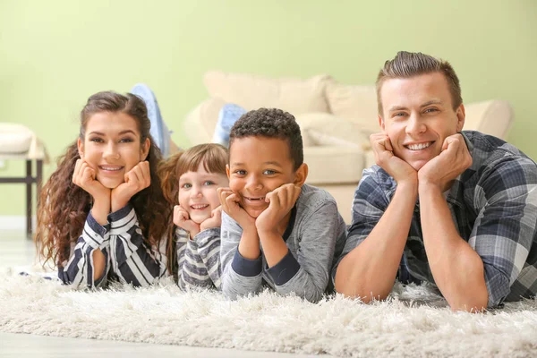 Happy couple with little adopted children at home — Stock Photo, Image