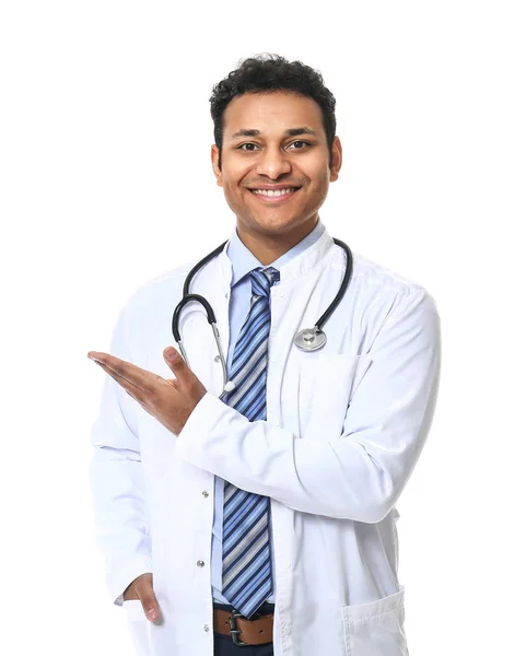 Knappe mannelijke arts die iets op witte achtergrond toont — Stockfoto