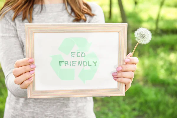 Jeune femme tenant conseil avec texte ECO FRIENDLY extérieur — Photo