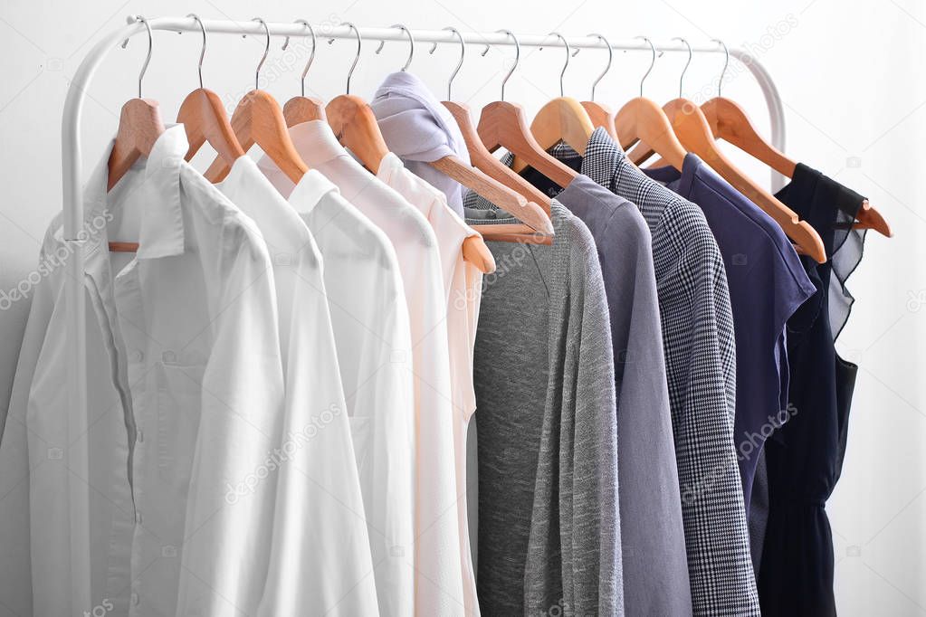 Rack with stylish clothes in room