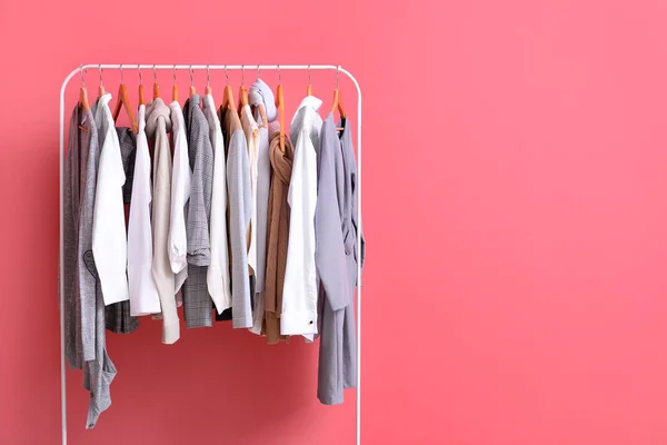 Bastidor con ropa elegante sobre fondo de color — Foto de Stock