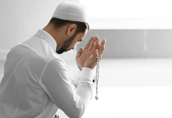 Young Muslim man praying indoors — Stock Photo, Image