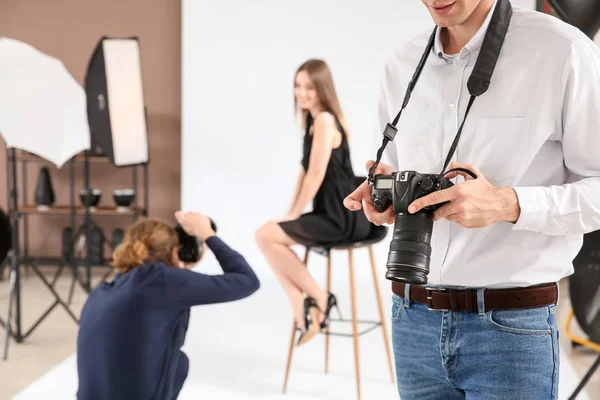 Fotógrafo profissional com câmera moderna em estúdio — Fotografia de Stock