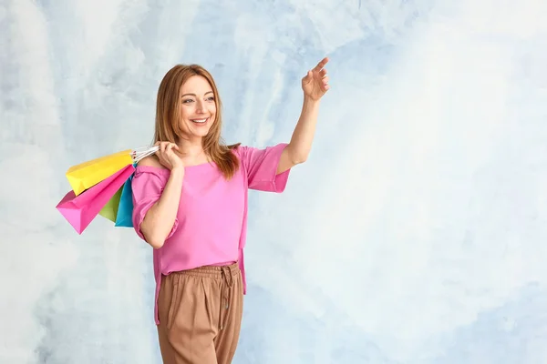 Portret dojrzałej kobiety z torby na zakupy na jasnym tle — Zdjęcie stockowe