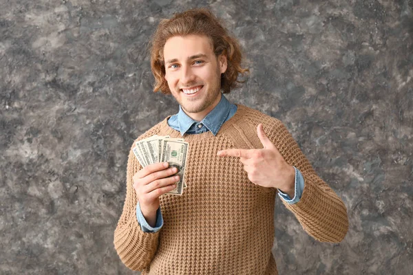 Joven feliz con billetes de dólar sobre fondo grunge — Foto de Stock