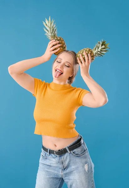 Zabawna młoda kobieta z ananasów na kolorowym tle — Zdjęcie stockowe