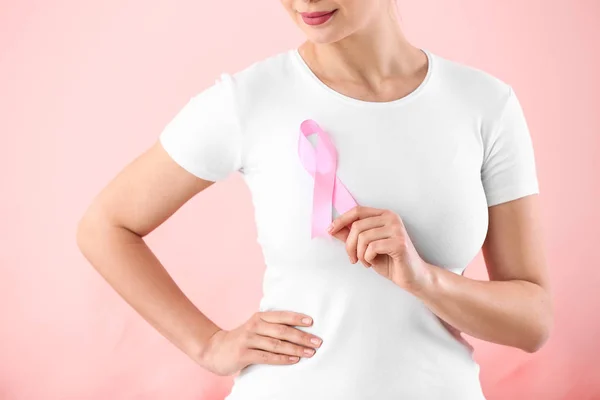 Jovem com fita rosa no fundo da cor. Conceito de consciência do câncer de mama — Fotografia de Stock