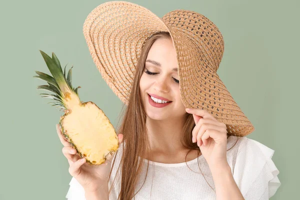 Mooie jonge vrouw met de helft van ananas op kleur achtergrond — Stockfoto