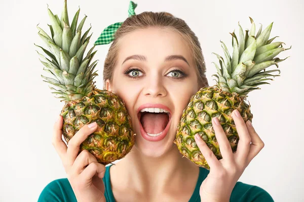 Jeune femme excitée avec des ananas sur fond blanc — Photo