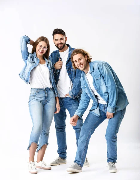 Elegantes jóvenes en ropa vaquera sobre fondo blanco — Foto de Stock