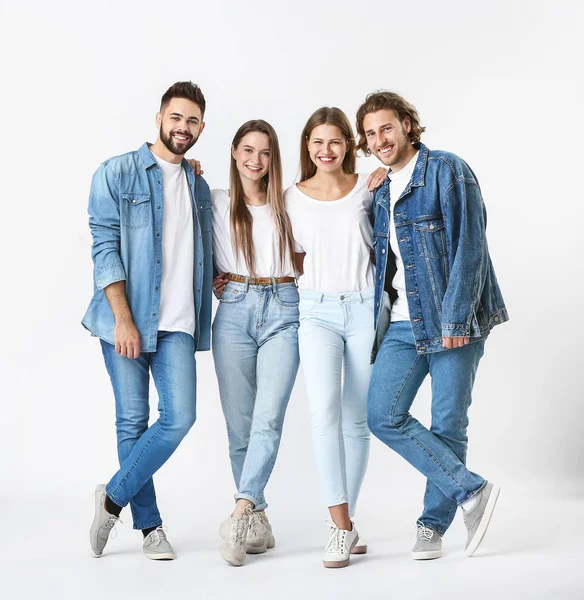 Jovens elegantes em jeans roupas em fundo branco — Fotografia de Stock