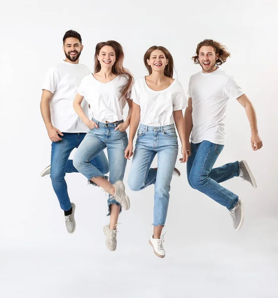 Jóvenes saltando en jeans sobre fondo blanco — Foto de Stock