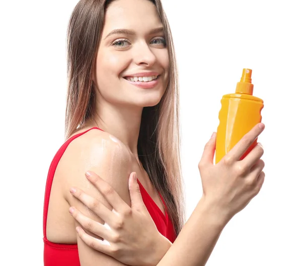 Beautiful young woman with bottle of sun protection cream on white background — Stock Photo, Image