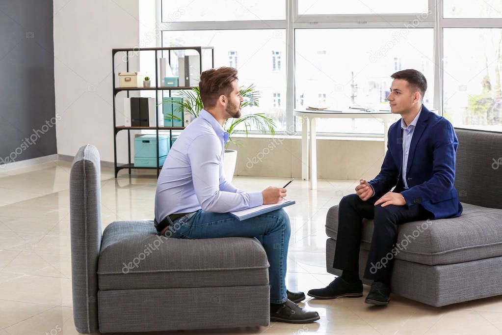 Human resources manager interviewing man in office