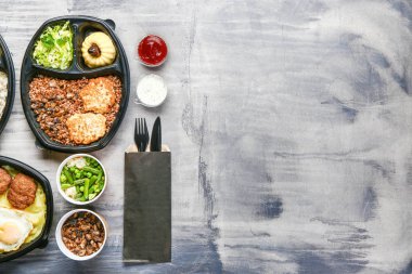 Gri zemin üzerine lezzetli yemekleri ile konteyner