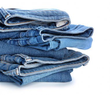 Beyaz arka planda kot pantolon yığını