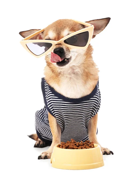 Uroczy pies Chihuahua z okularem przeciwsłonecznymi w pobliżu miski z jedzeniem na białym tle — Zdjęcie stockowe