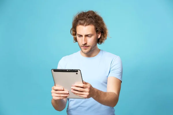 Handsome man with tablet computer on color background — Stock Photo, Image