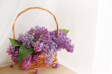 Pencere yakınında masada güzel leylak çiçekleri ile Sepet