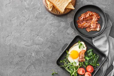 Gri arka planda lezzetli kızarmış yumurta ve pastırma ile Kompozisyon