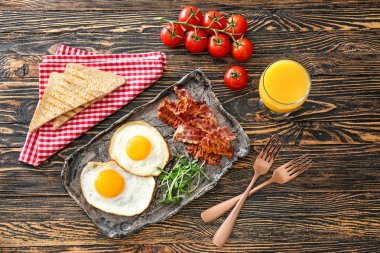 Ahşap arka planda lezzetli yumurta, pastırma ve tost ile kompozisyon