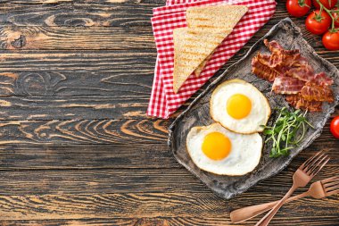Ahşap arka planda lezzetli yumurta, pastırma ve tost ile kompozisyon