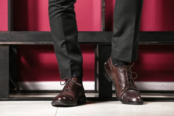 Stylish young man in modern shoes near color wall — Stock Photo, Image