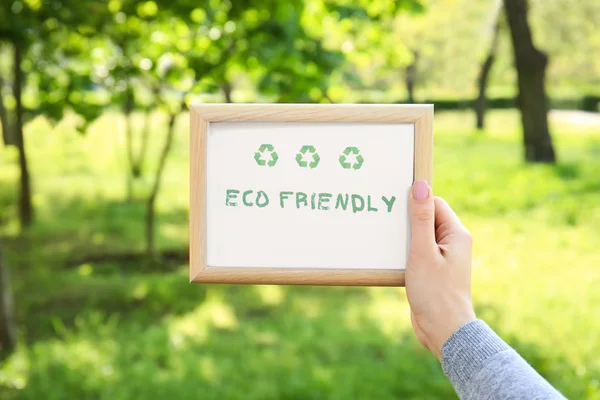 Samica ręka trzyma deska z tekstem Eco Friendly na zewnątrz — Zdjęcie stockowe