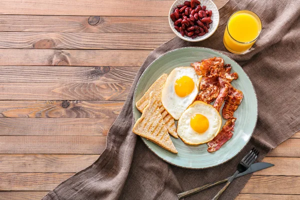 Tasty English breakfast  with fried eggs, bacon, beans and toasts on table — Stock Photo, Image