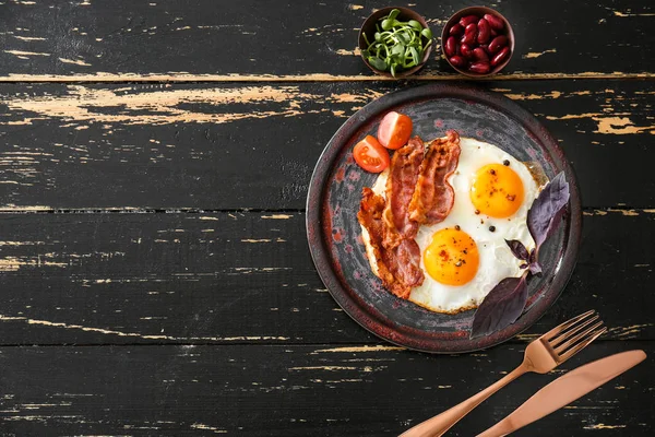 Plate with tasty fried eggs, bacon and tomato on table — Stock Photo, Image