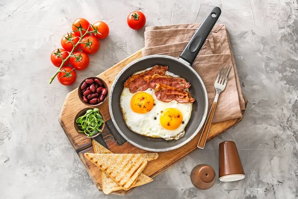 Traditional English breakfast with fried eggs, bacon, beans and toasts on table — Stock Photo, Image