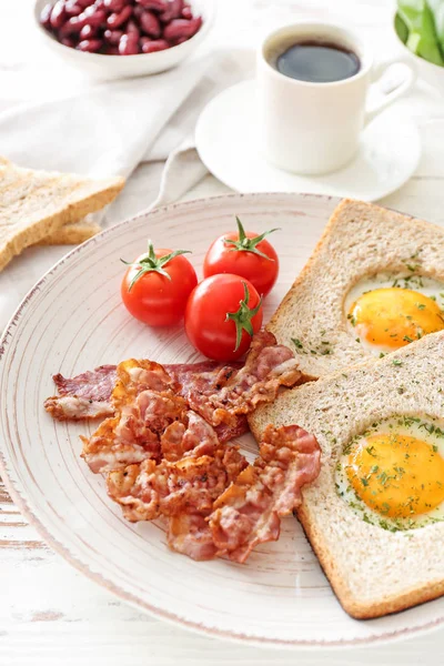 Talíř s chutnými smaženými vejci, slaninou, toastami a rajčaty na dřevěné pozadí — Stock fotografie