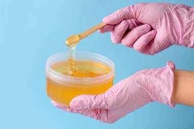 Renk arka planda epilasyon için şekerleme macun ile Kadın eller