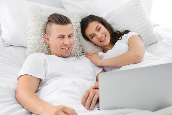 Schattig liefdevolle paar kijken naar film in bed thuis — Stockfoto