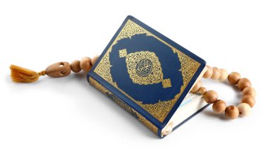 Beyaz arka planda Müslüman boncukları ve Kuran