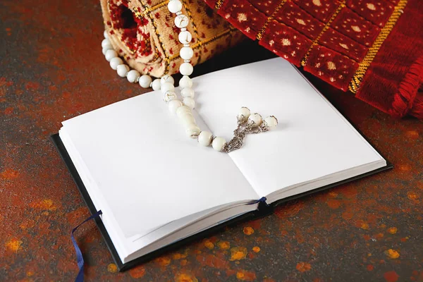 Muslim prayer mat, beads and Koran on grunge background — Stock Photo, Image