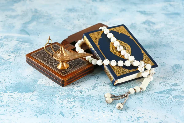 Koran, rehal, lamp and Muslim beads on color background — Stock Photo, Image