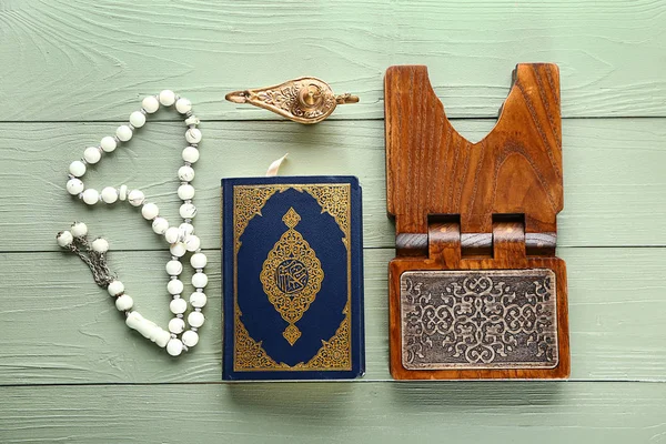 Koran, rehal, Muslim beads and lamp on wooden background — Stock Photo, Image