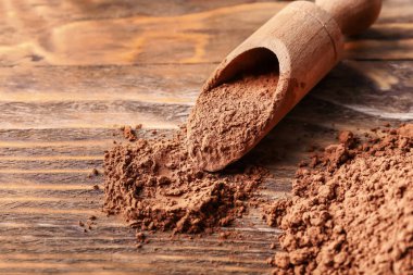 Ahşap arka plan üzerinde kakao tozu ile Kepçe, closeup