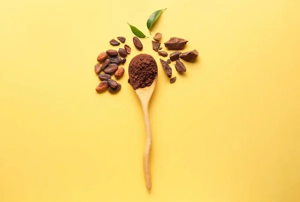 Spoon with cocoa powder, beans and chocolate on color background — Stock Photo, Image