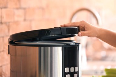 Mutfakta modern çoklu fırın kullanan kadın, yakın plan.