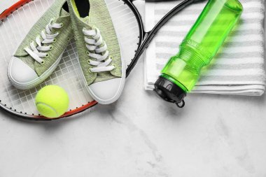 Tenis raket, ayakkabı, havlu, hafif arka planda su ve top şişesi